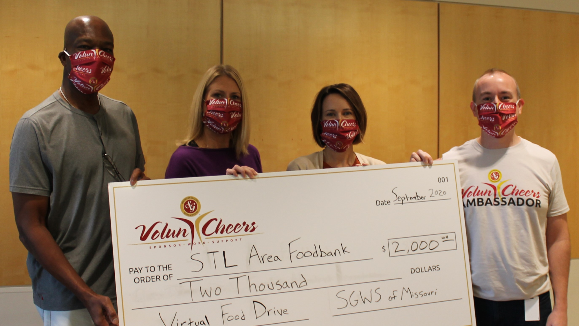 Voluncheers members presenting large check to virtual food drive
